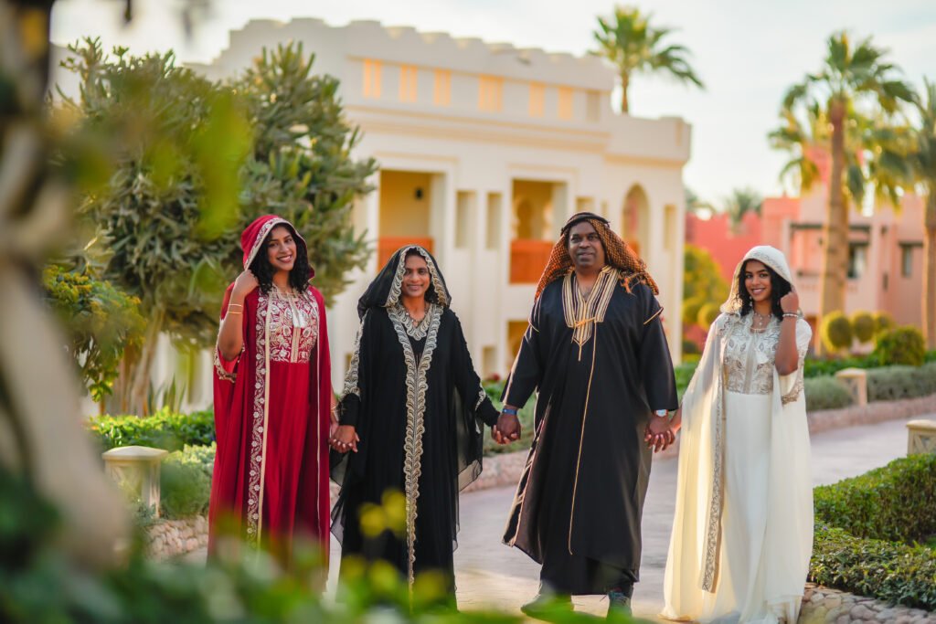 family in an Arabian abaya during a photoshoot in Sharm El Sheikh’s desert at sunset.