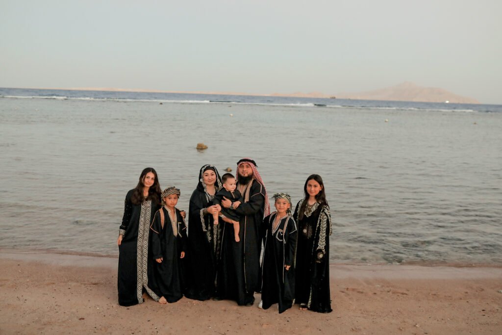 Family posing for Sharm family photos on the beach.
