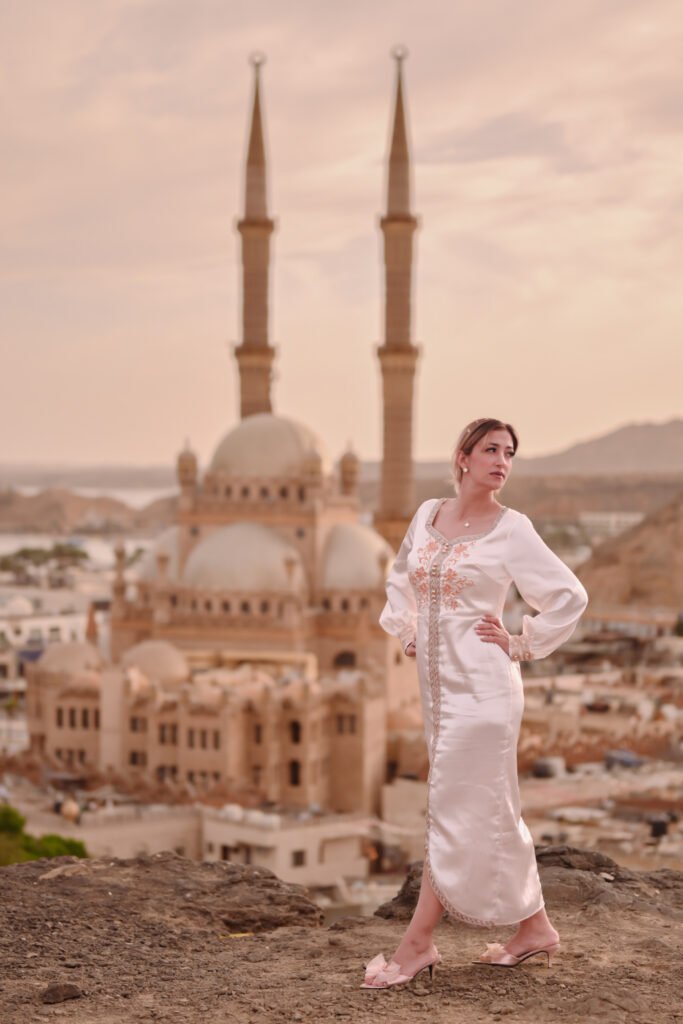 Woman in modest attire during an Al Sahaba Mosque photoshoot in Sharm El Sheikh at sunset.