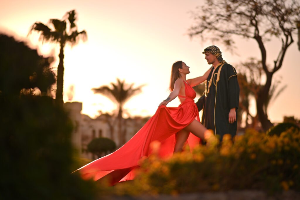Couple posing in a flying dress during a professional shooting in Sharm El Sheikh at sunset by the Red Sea.
