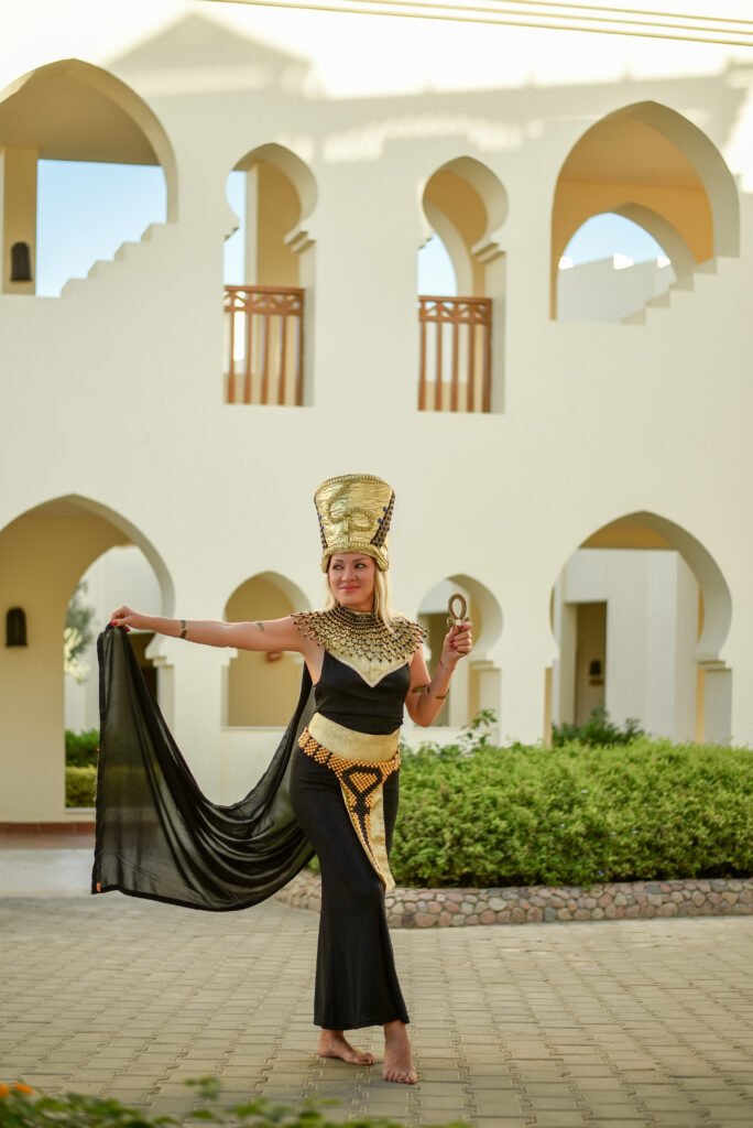 Woman in a Pharaonic-style costume during a photoshoot in Sharm El Sheikh’s desert at sunset.