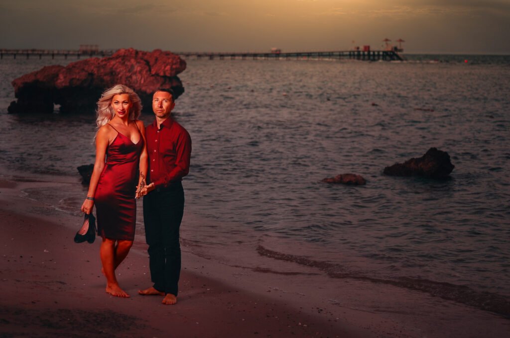 Couple posing for Sharm couple photos at sunset by the sea.