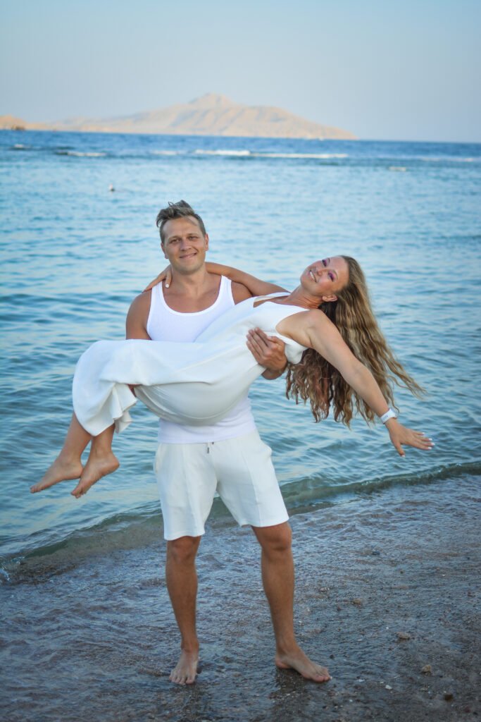 Couple posing for Sharm El Sheikh beach photography by the sea at sunset.